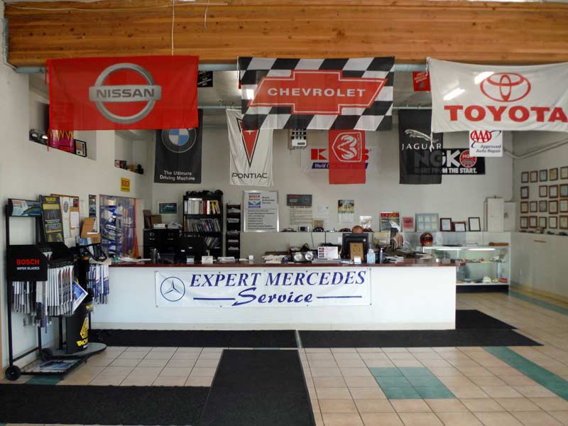 Our front counter with the Expert Mercedes Service banner and manufacturer flags hanging from the ceiling beam