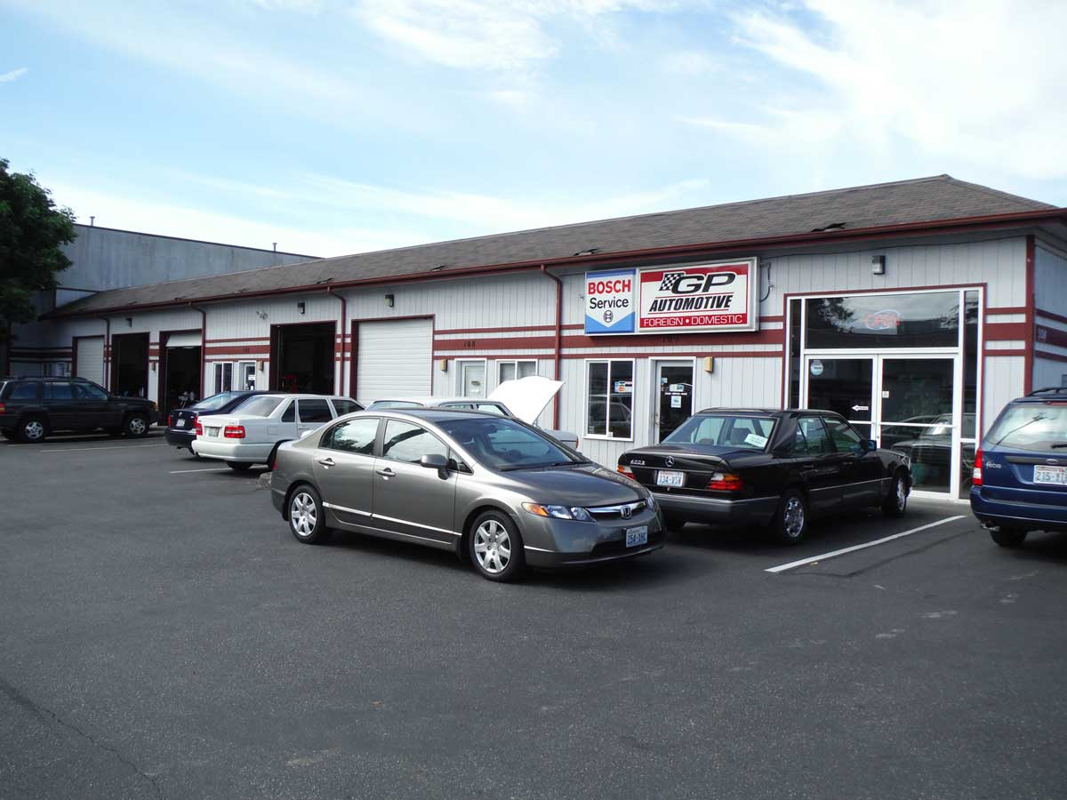 The front of our building on 132nd Street SW, roll-up doors open and customer cars in the lot